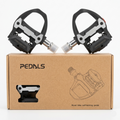 A pair of black Promend PD-R97B self-locking road bike pedals with silver metal wear plates resting on top of their original brown cardboard retail box.
