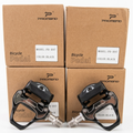 Front view of a pair of black Promend PD-R97 road bicycle clipless pedals resting against four brown Promend retail boxes showing the model name.