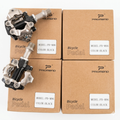 Top-down view of two black Promend PD-M96 dual-sided mountain bike pedals angled over four brown retail cardboard boxes displaying the model label.