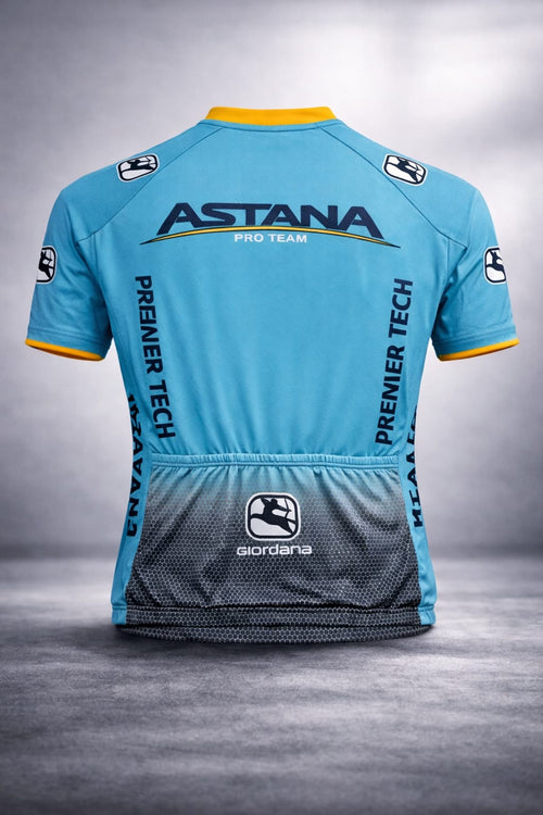 Back view of the Astana Pro Team cycling jersey showing three rear pockets, a dark gray honeycomb gradient at the waist, and Premier Tech branding.