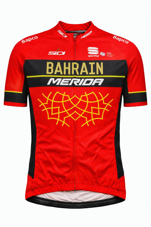 Front view of Bahrain Merida short sleeve cycling jersey in crimson red and black featuring a gold geometric pattern on the chest