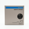 Front view of the cardboard-colored Shimano retail box packaging for the 105 CS-R7000 11-speed road bike cassette, with a black checkmark marked next to the 11-30T specification.