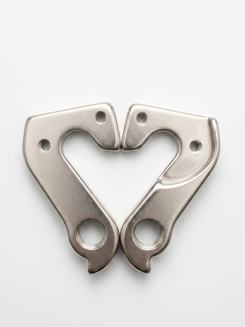 Dual silver metallic DH004 rear derailleur hangers arranged symmetrically in a heart shape on a clean white background.