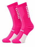 Pair of Giro performance crew-height cycling socks in vibrant hot pink and white, showing breathable mesh texture and compression arch support against a plain white background.