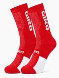 Pair of Giro performance crew-height cycling socks in vibrant racing red and white, displaying high-breathability honeycomb mesh patterns and compression arch support against a plain white background.