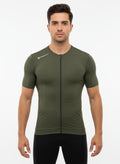 Front studio shot of a male model wearing a tight-fitting olive green Reeck short sleeve cycling jersey featuring a full-length zipper and a white logo on the shoulder.