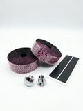 Premium vibrant pink bicycle handlebar tape rolls with a textured black and pink hexagon honeycomb pattern as shown in image, displayed next to two reflective chrome bar end plugs and two black adhesive finishing strips on a clean white background.