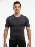 Front studio view of a male model wearing a tight compression-fit, dark blue Reeck short sleeve cycling jersey with a full-length front zipper and a white logo on the shoulder.