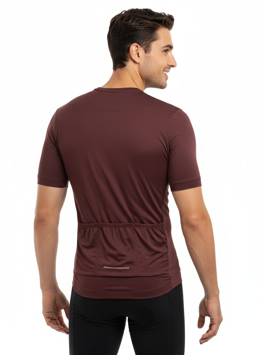 Angled rear view of a male model showing the ergonomic fit, short sleeves, and deep cargo storage pockets of the burgundy Reeck cycling jersey.