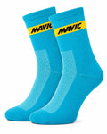 Pair of Mavic performance crew-height cycling socks in a vibrant sky blue colorway, featuring a single horizontal yellow accent stripe at the cuff with black Mavic text branding and a white-flecked mesh ventilation panel on the instep, displayed against a plain background.