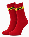 Pair of Mavic performance crew-height cycling socks in vibrant racing red, featuring a single horizontal yellow accent stripe at the cuff with black Mavic text branding, displayed against a plain background.