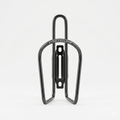 Front view of a sleek, matt black Merida aluminum alloy bicycle water bottle cage with a clean tubular design and slotted mounting spine, isolated on a plain white background.