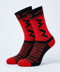 A pair of NORTHWAVE performance crew cycling socks in a bold red and black colorway, showcasing geometric NW branding on the upper cuff and a textured mesh design over the foot, displayed upright against a clean background