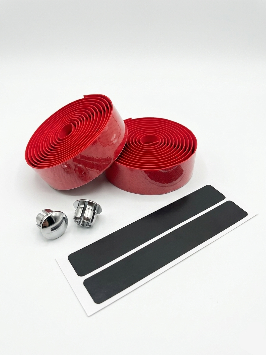 Premium racing red bicycle handlebar tape rolls with a glossy micro-diamond texture pattern as shown in image, displayed next to two metallic chrome bar end plugs and two black adhesive finishing strips on a bright white background.