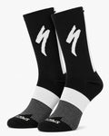 A pair of SPECIALIZED crew cycling socks in a solid black colorway featuring a white midfoot block, a vertical white stripe down the back, and the iconic white lightning bolt logo on the upper cuff, displayed upright against a clean white background