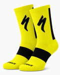 A pair of SPECIALIZED crew cycling socks in a vibrant high-visibility yellow colorway featuring a black midfoot compression band, a vertical black stripe down the back, and the iconic black lightning bolt logo on the upper cuff, displayed upright against a clean white background